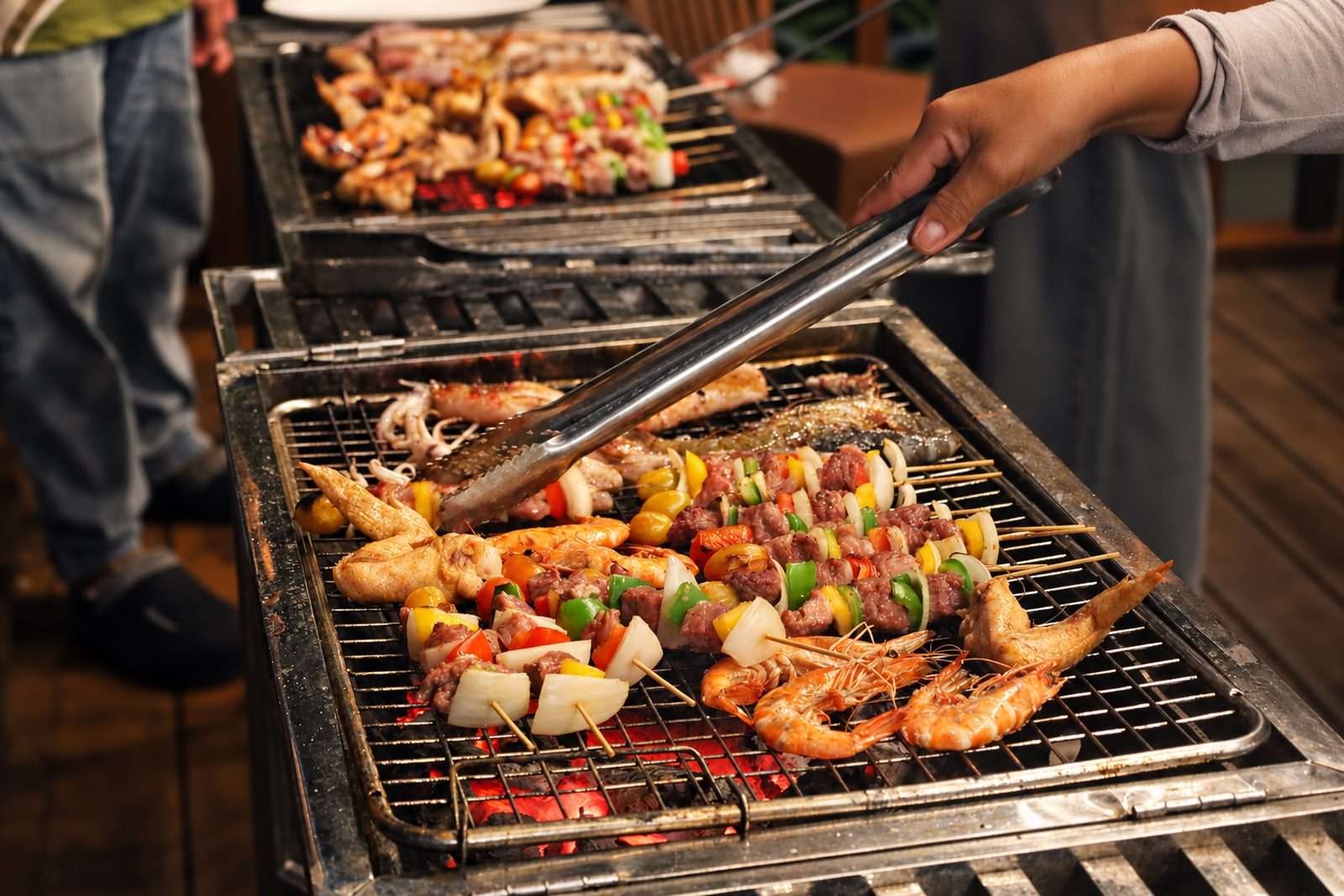 Seafood and vegetable skewers grilling over charcoal