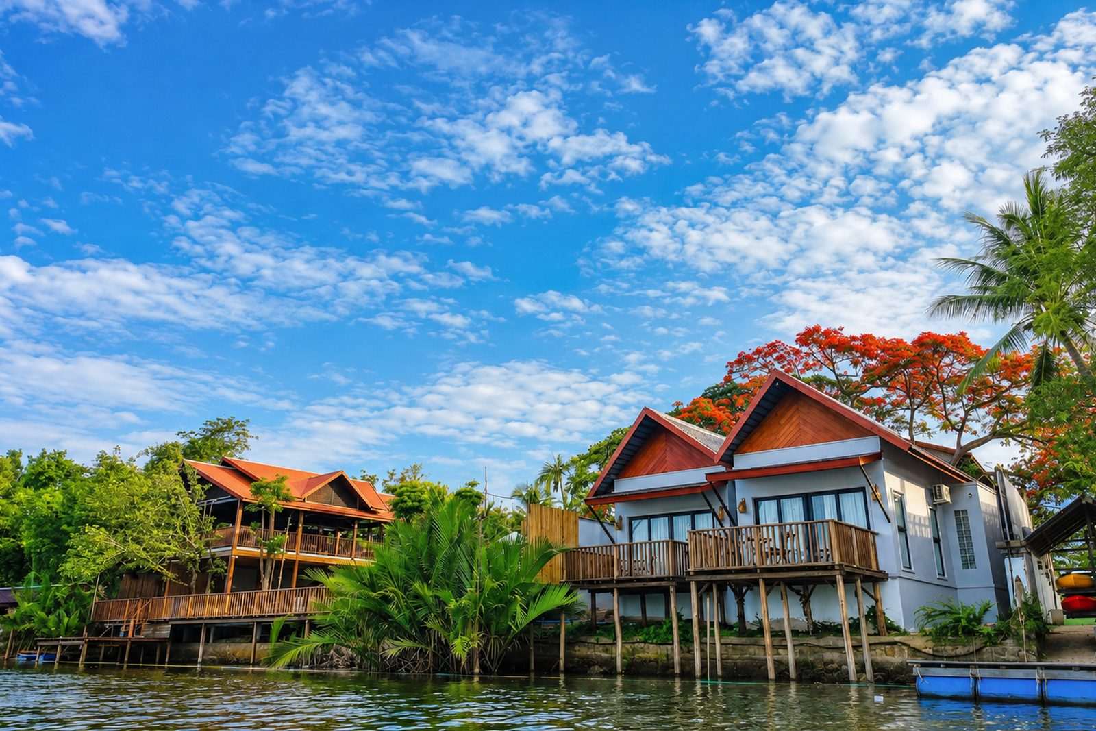 The resort seen across the water, timber bungalows among the trees