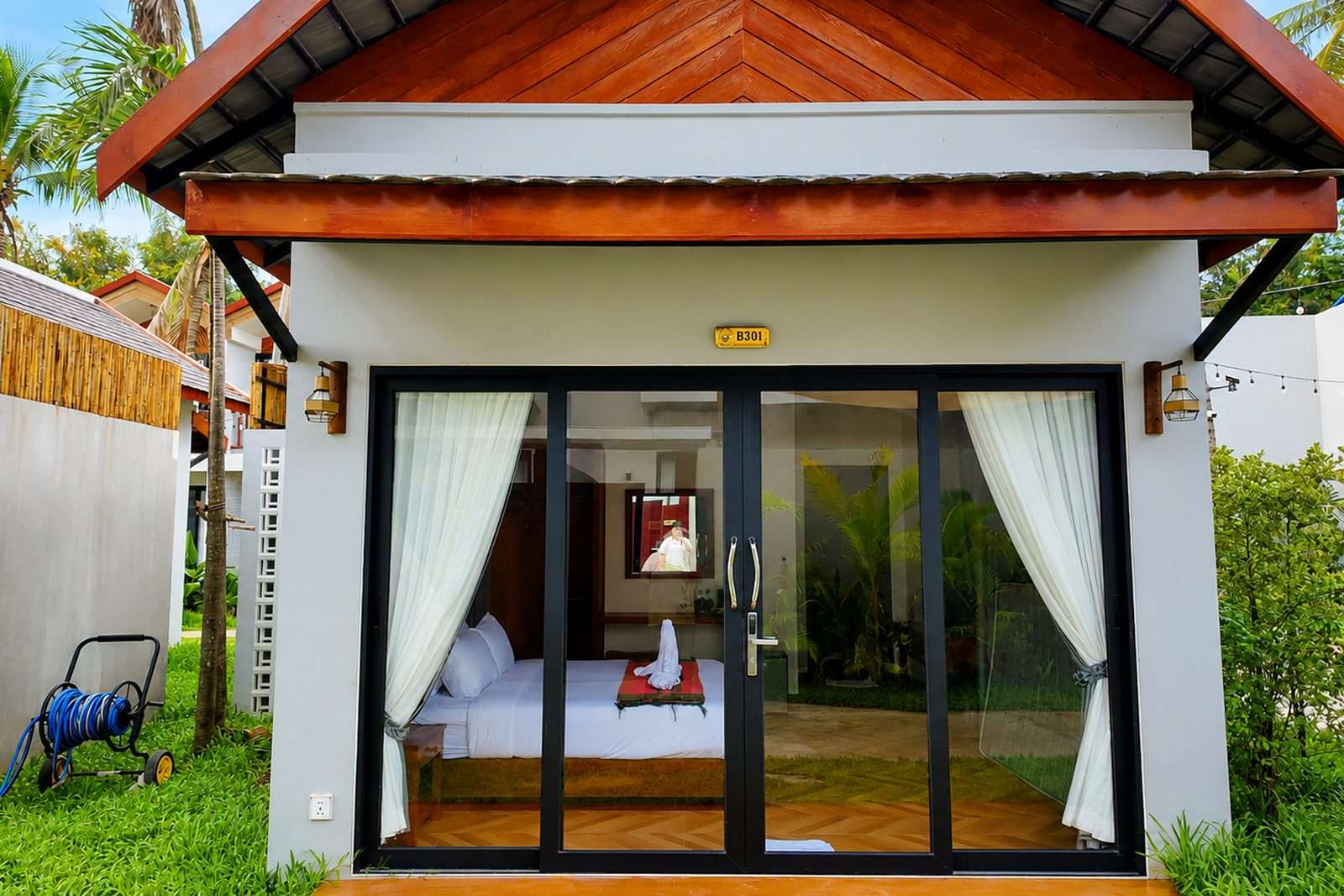 The front of a garden bungalow with glass doors and a pitched tile roof