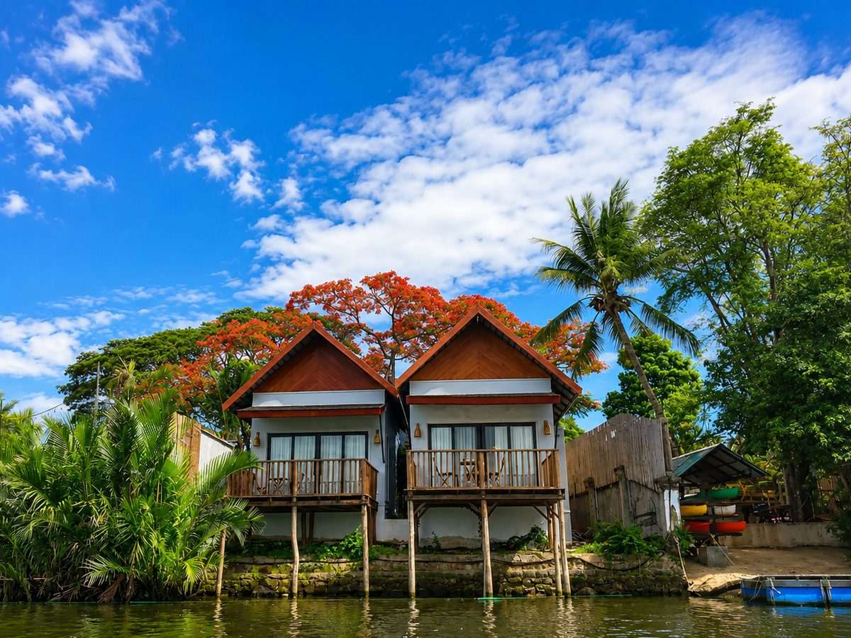A timber riverside bungalow on stilts above the water, with a private balcony